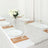 Elegant table setting with white plates, gold accents, and floral centerpiece.
