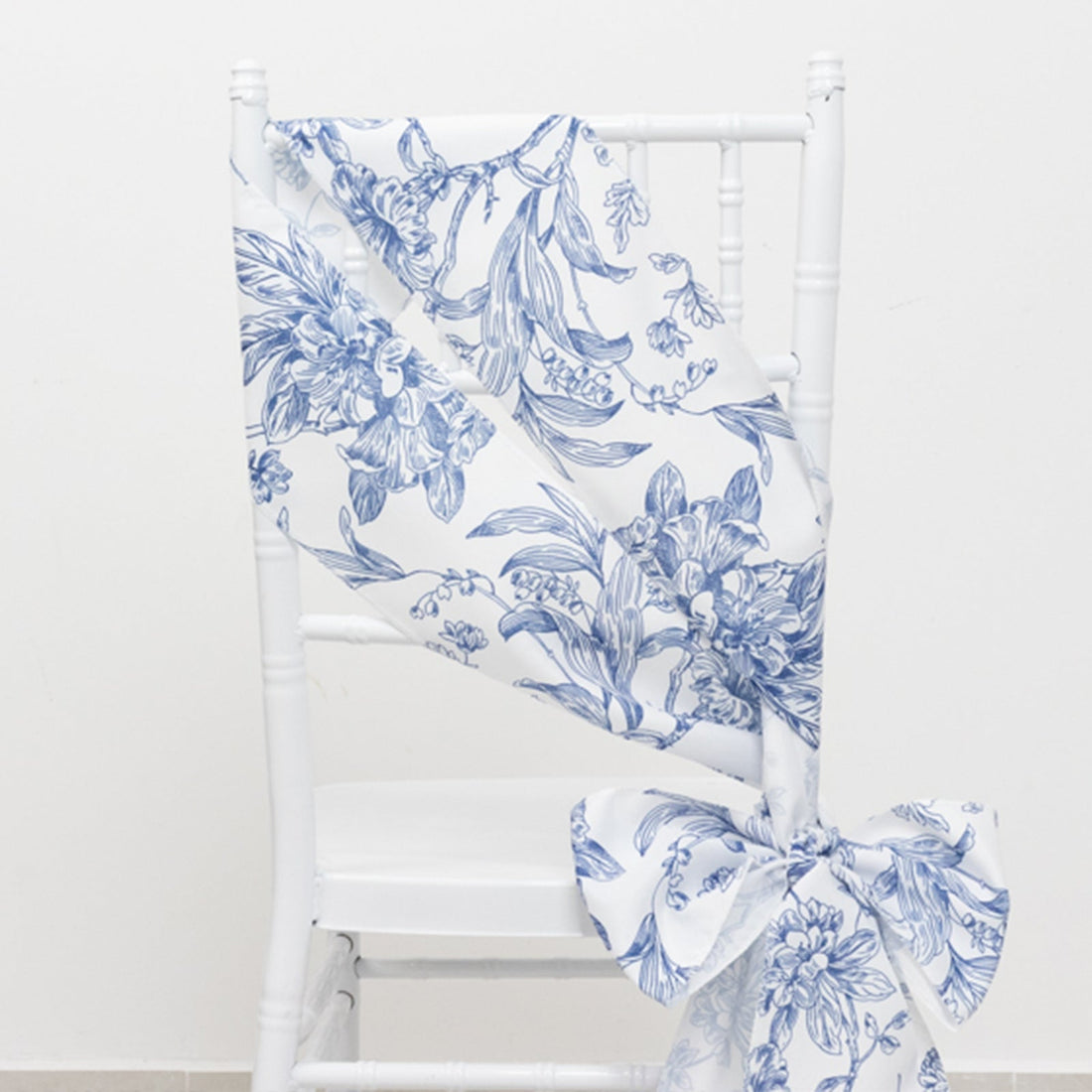 Blue floral chair sash draped elegantly on a white chair