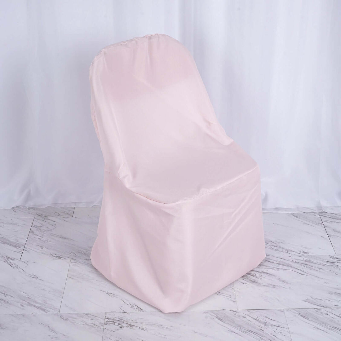 Pink chair cover on a plain backdrop for furniture protection.