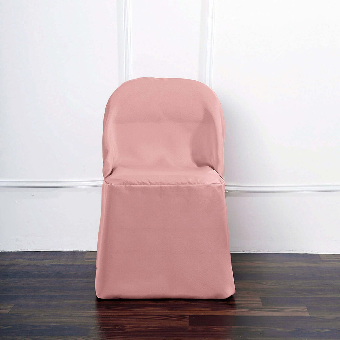 Pink chair cover on a wooden floor against a white wall.