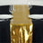 Gold table runner on a black table setting with glasses and plates.