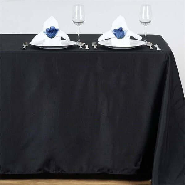 Elegant black tablecloth set with fine dining setup and decorative napkins.