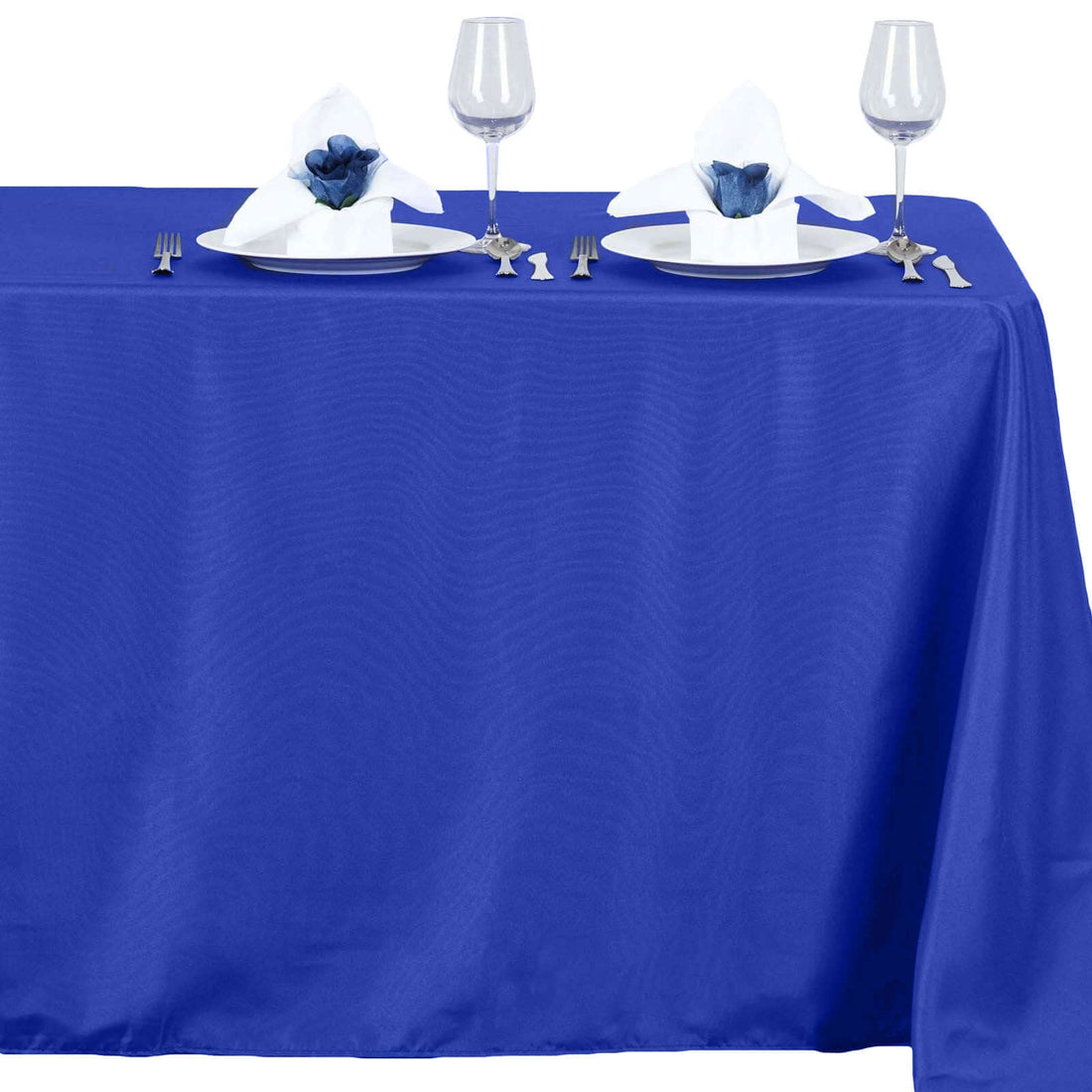 Blue tablecloth with elegant napkin and glassware setup.