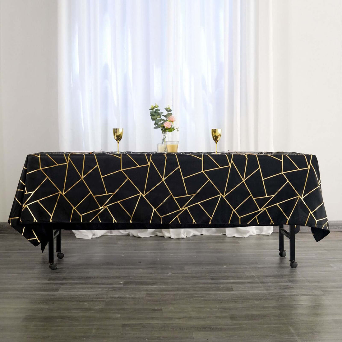 Elegant black tablecloth with gold geometric patterns on a styled table setting.
