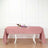 Pink tablecloth draped over a dining table with wine and plates