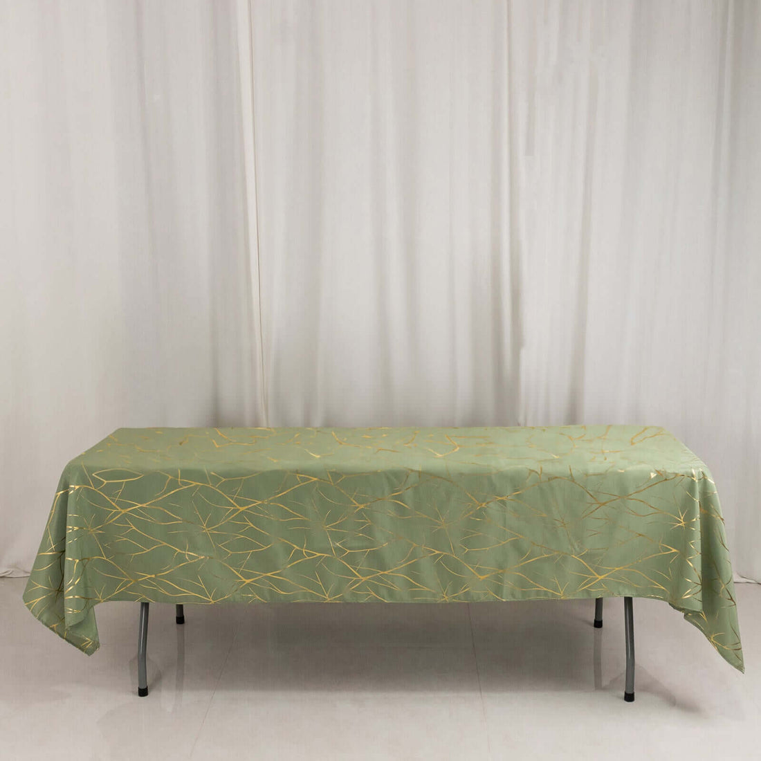 Green tablecloth with gold leaf design on a table.