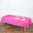 Pink tablecloth draped over a table set with plates and glasses.