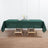Green tablecloth draped on wooden table with floral centerpiece