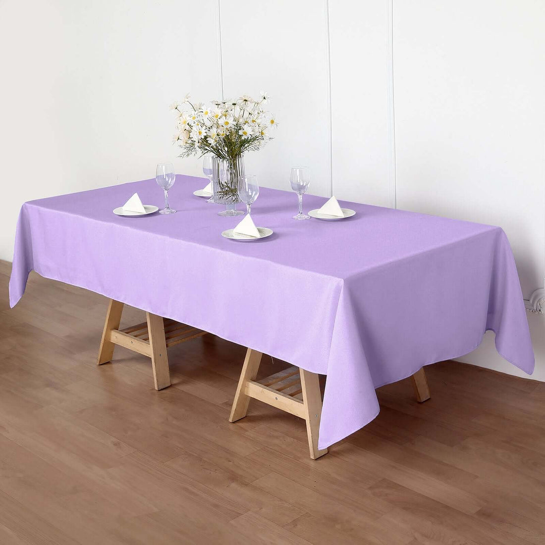 Lavender tablecloth draped over a wooden table set for dining.