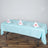 Table set with blue tablecloth, plates, glasses, and napkins for an elegant dining experience.