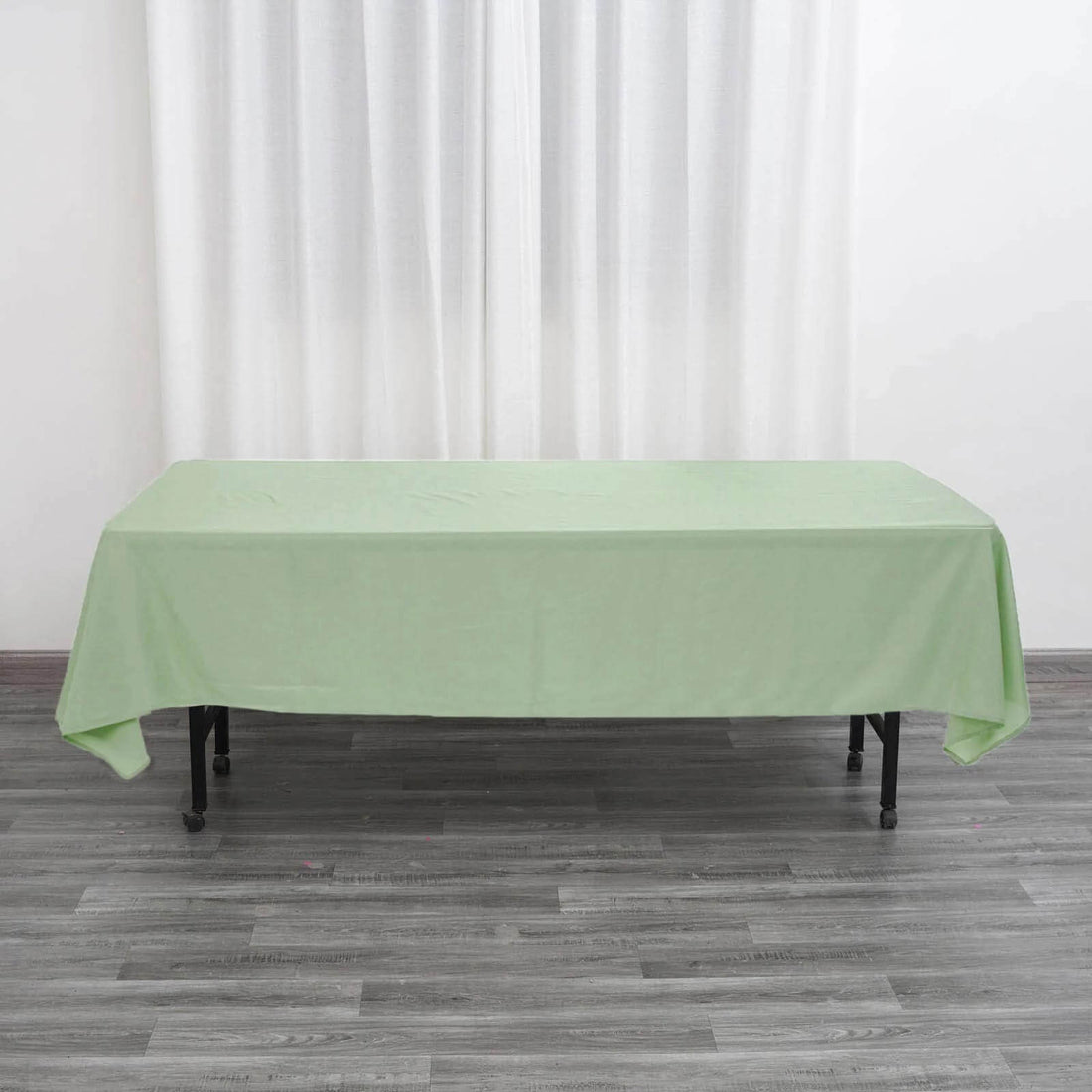 Green tablecloth draped over a table, showcasing its full shape.