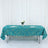 Teal tablecloth with geometric gold design on a table with floral centerpiece