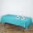 Turquoise tablecloth draped over a table with plates and glasses.
