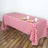 Red and white checkered tablecloth on a wooden table with plates and cups.