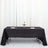Black tablecloth elegantly draped on a table set for dining with flowers and glassware.