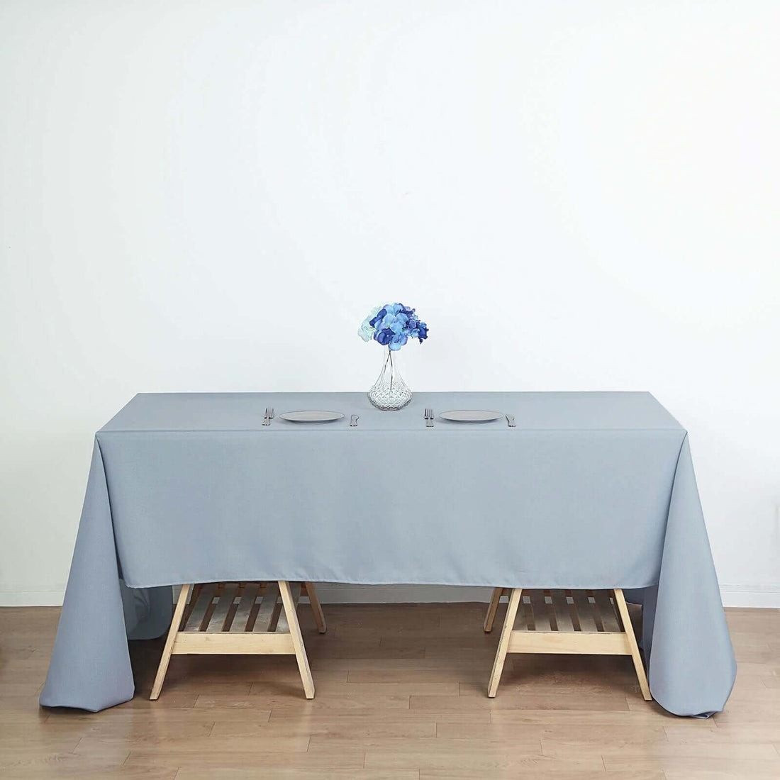 Elegant grey tablecloth draped over a wooden table with a floral centerpiece.