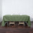 Green tablecloth draped over a wooden table with glasses and napkins.