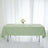Green tablecloth draped over a table with a floral centerpiece and plates.