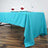 Turquoise tablecloth draped on a table with elegant napkin decorations.