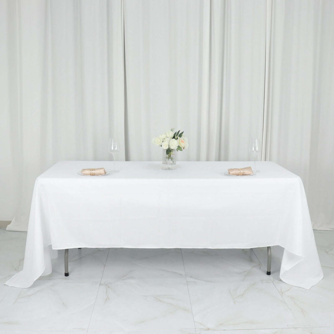Elegant dining table set with white tablecloth and floral centerpiece