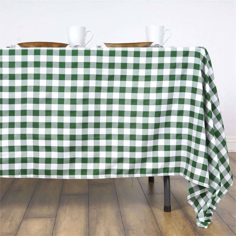 Green and white checkered tablecloth draped on a table with dishes on top.