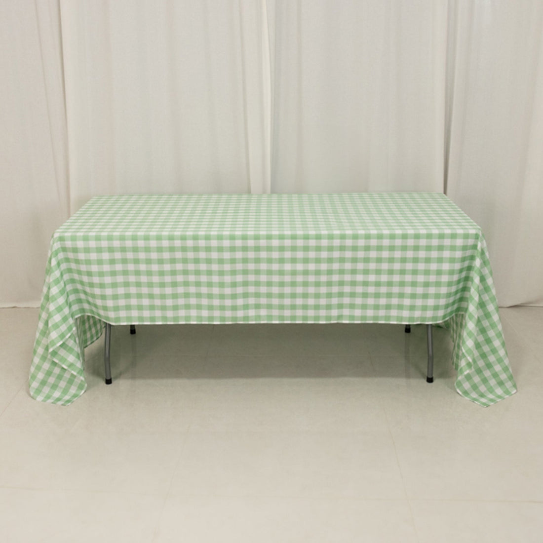 Green gingham tablecloth draped over a table in a studio setting