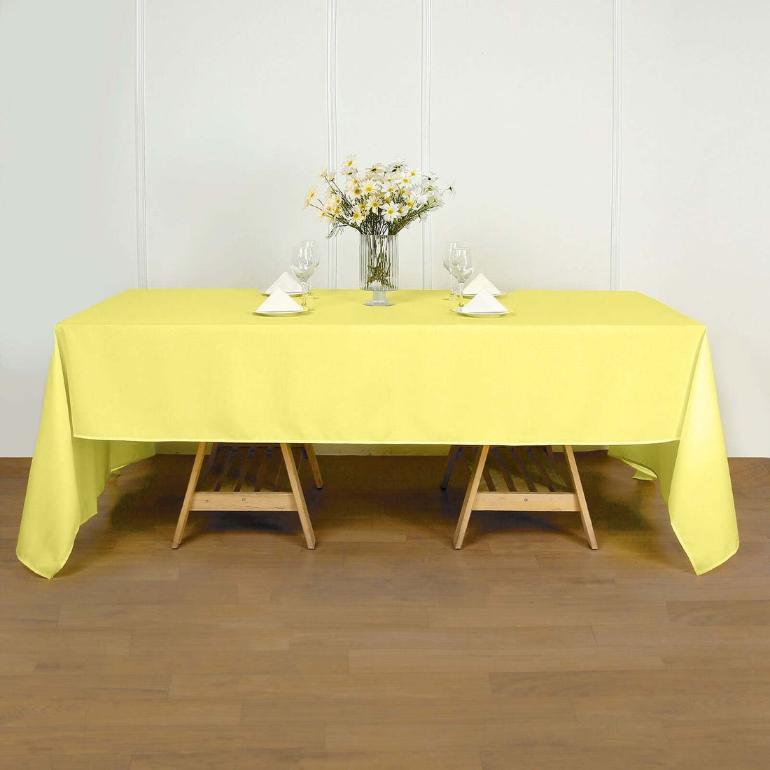 Yellow tablecloth draped over a wooden table with decorative elements.