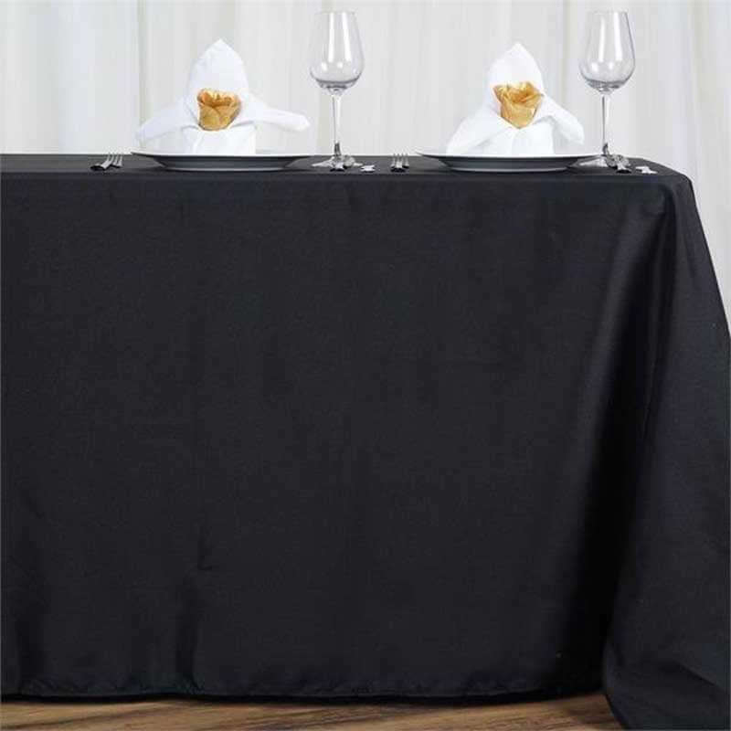 Black tablecloth with decorative duck napkins and wine glasses.