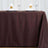 Brown tablecloth draped elegantly on a dining table with decorative napkin swans.