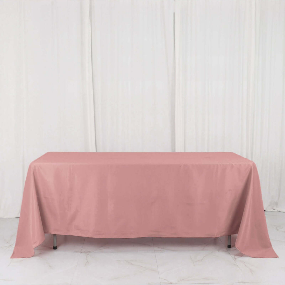 Pink tablecloth draped over a table in a studio setting