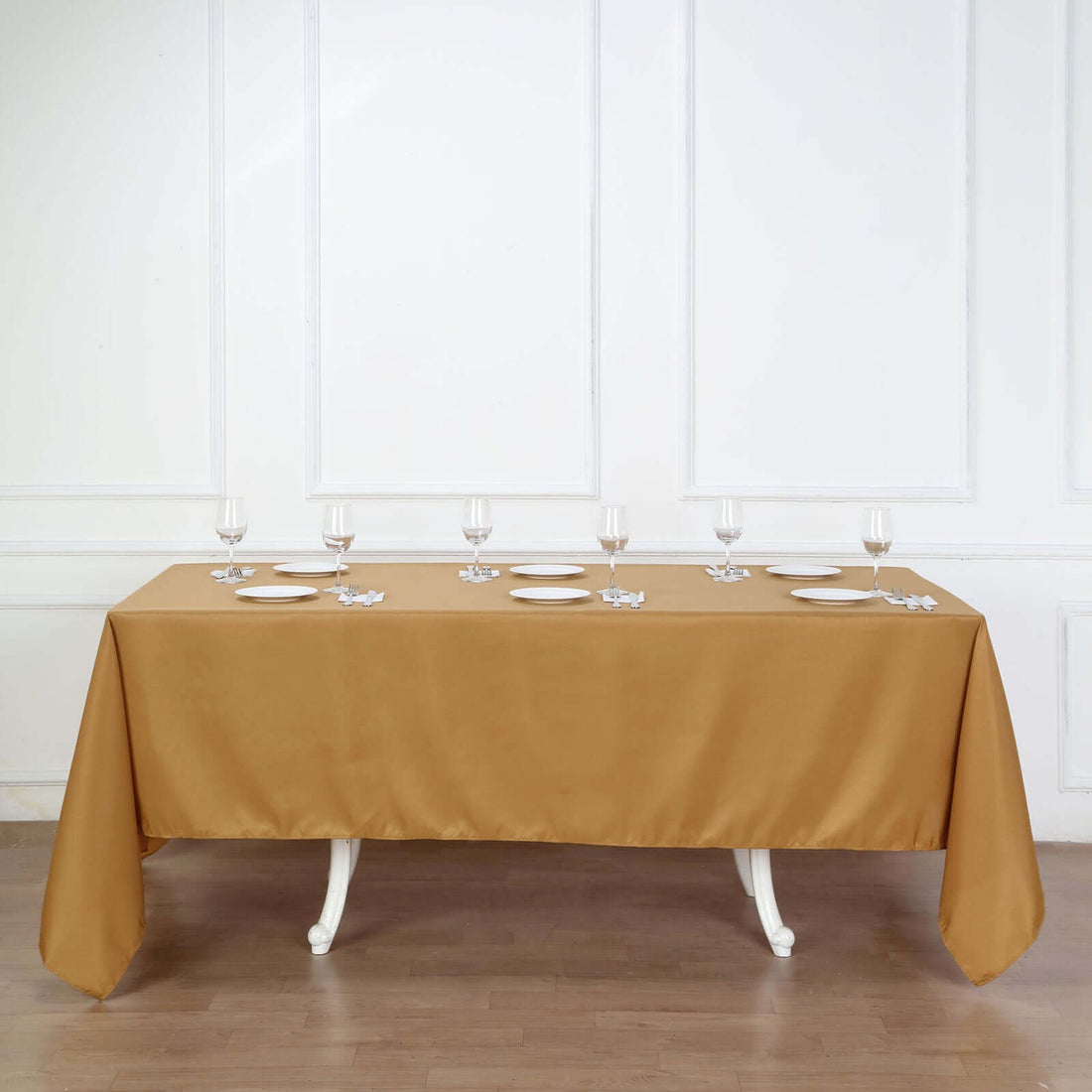 Brown tablecloth draped over a table set with plates and glasses.