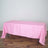 Pink tablecloth draped over a table on a wooden floor.