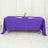 Purple tablecloth draped over a table with plates and a flower vase.