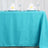 Turquoise tablecloth with elegant napkin presentation on a dining table.