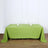 Green tablecloth on a dining table set for two with glasses and napkins.