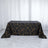 Black tablecloth with gold geometric pattern on a table.