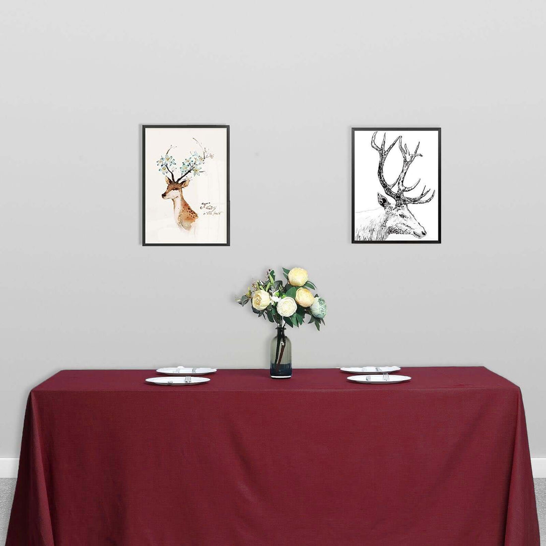 Framed deer art prints above a table set with flowers and tableware.