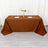 Brown tablecloth draped over a table set for dinner with plates and flowers.