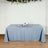 Blue tablecloth draped over a table with decorative items and glasses.