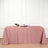 Pink tablecloth draped over a table with wine and floral decor