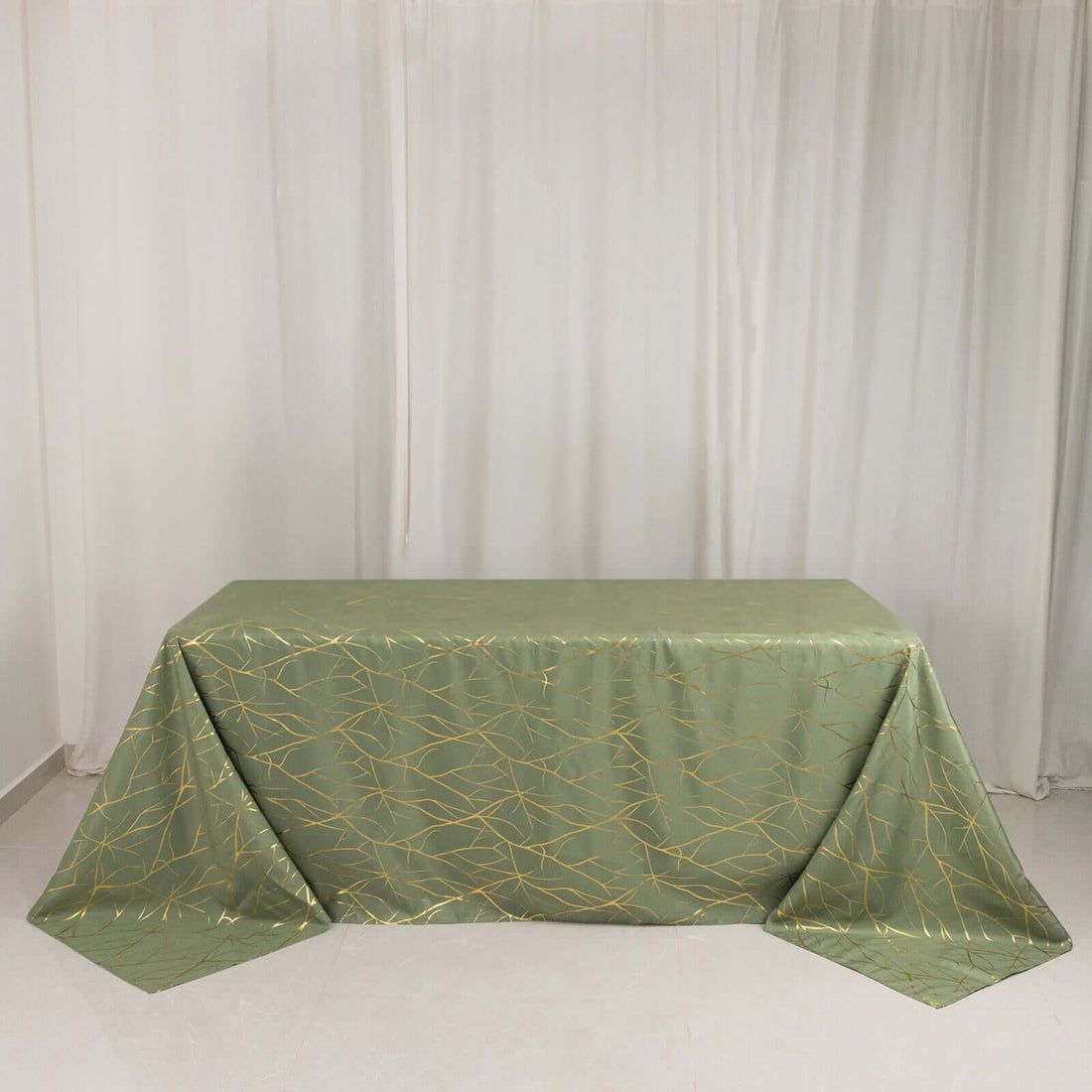 Green tablecloth with gold geometric design on a plain backdrop.