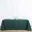 Green tablecloth on a wooden surface with a vase and plate.