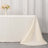 Elegant cream tablecloth draping over a table with floral centerpiece and glass.