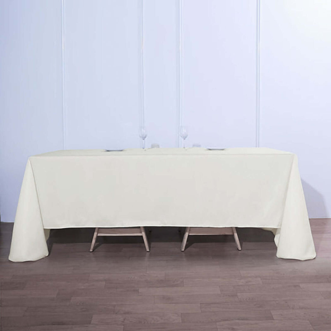 Cream tablecloth draped over a wooden table in a minimalist setting.