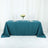 Teal tablecloth draped over a table with plates and flower vase
