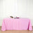 Pink tablecloth draped over a table with wine glasses and flowers.
