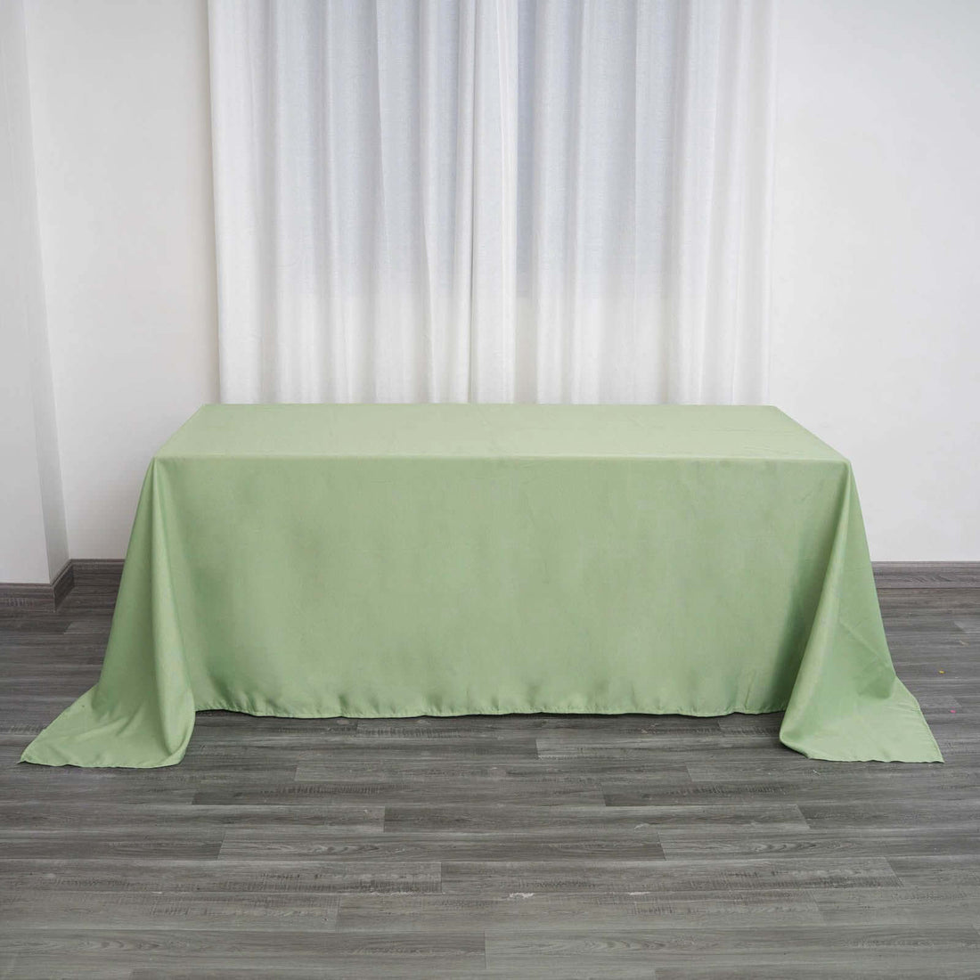Green tablecloth draped over a table in a bright room.