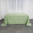 Green tablecloth draped over a table in a bright room.