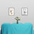Table set with a turquoise tablecloth, floral centerpiece, and framed deer art on the wall.