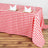 Red and white checkered tablecloth with plates and napkins set for dining.